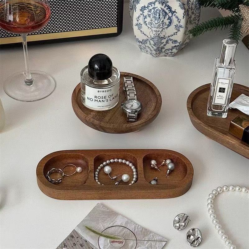 Carved walnut jewelry tray holding rings and earrings