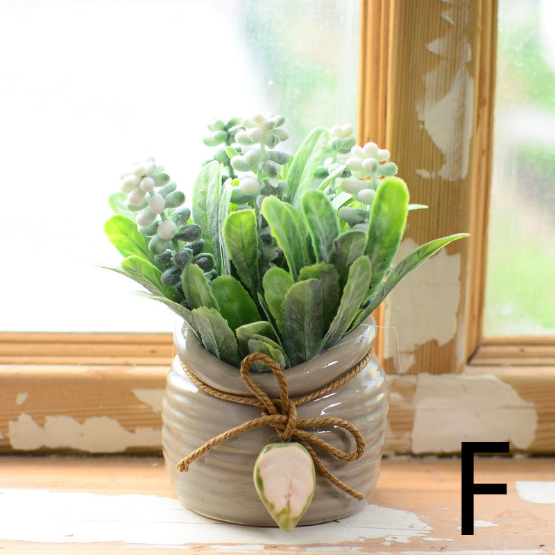 Artificial mini bonsai in a small ceramic pot on a desk