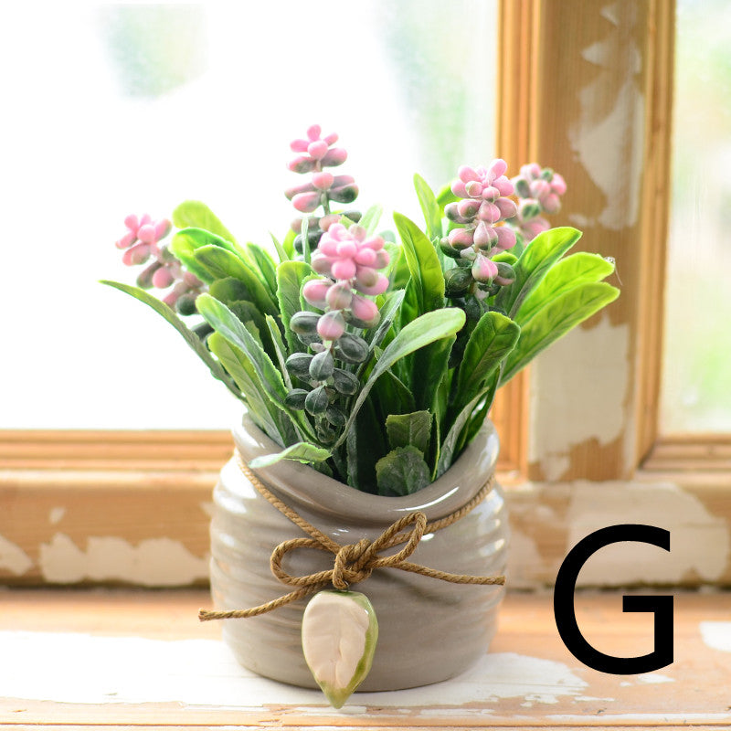Pink artificial buds in gray ceramic jar tied with twine on windowsill – Pausadesk