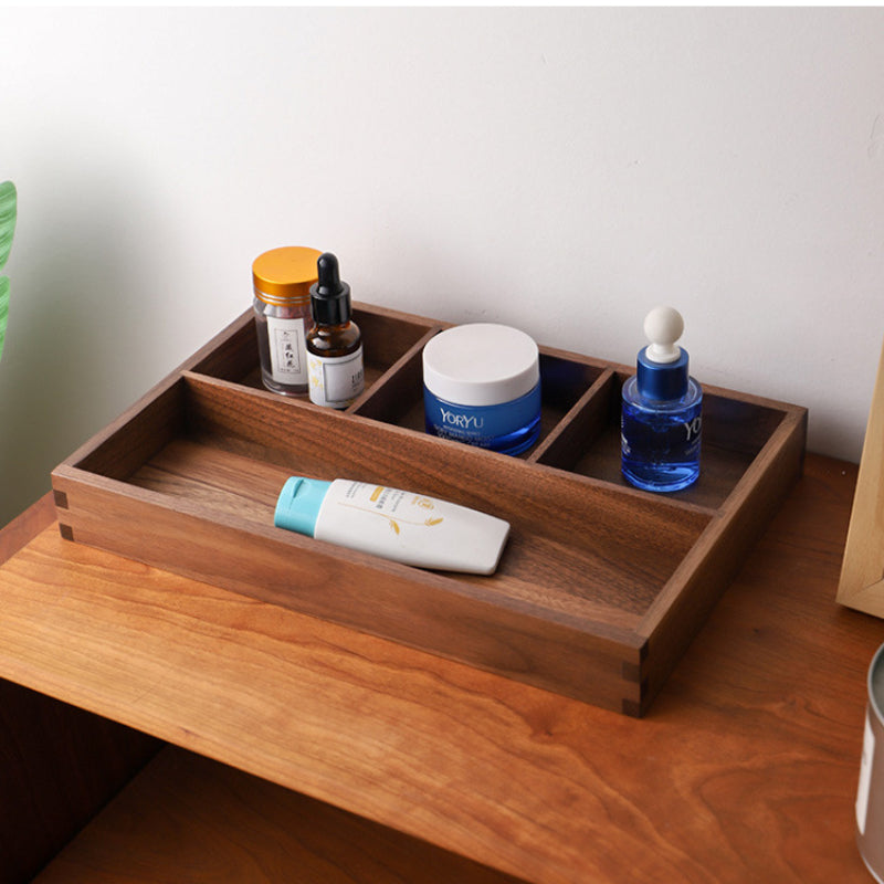 Walnut divided storage box holding skincare jars and dropper bottles on a light wood table – Pausadesk