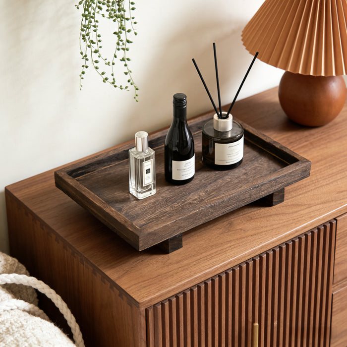 Dark brown grooved wood desk tray with keys and pens