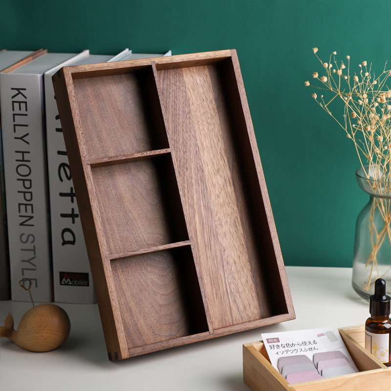 Empty walnut divided box leaning on books against a green wall with dried flowers – Pausadesk