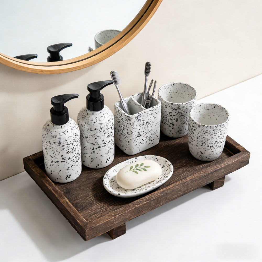 Dark wood tray holding ceramic toiletries below a round mirror on a bathroom counter – Pausadesk